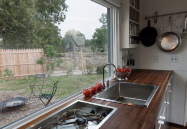 An in-counter, high Btu marine grade cooktop saves space by hiding under a cutting board. A foot pedal operates the faucet for better sanitation, water conservation, and convenience.